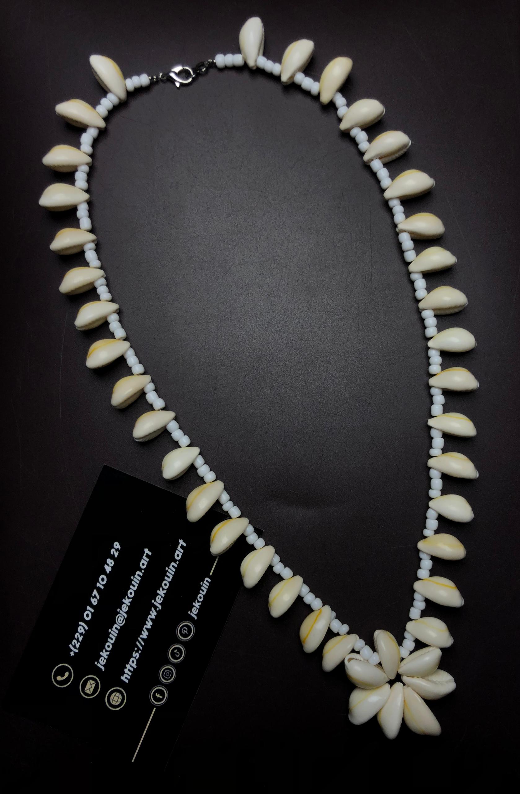 Vue d'ensemble montrant le collier "Chemin de divinité" disposé en ovale sur fond noir avec la carte de visite jekouin affichant ses coordonnées.