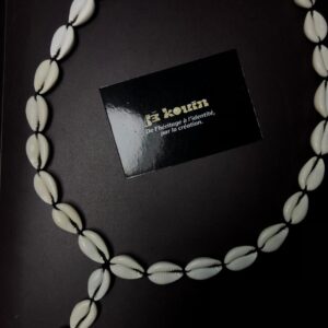 Vue d'ensemble du collier "Chapelet de noblesse" dessinait une grande boucle ovale en cauris avec la carte jekouin au centre