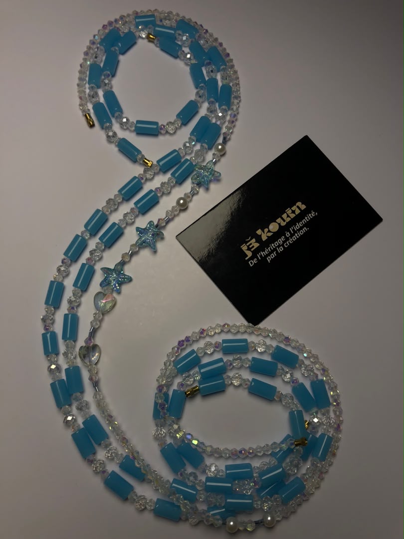 Vue complète du baya bleu turquoise "Bassins de corail" formant un S élégant sur fond blanc à côté de la carte jekouin.